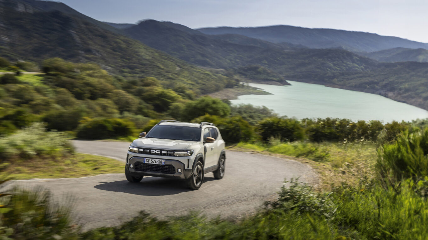 dacia duster dans une route entourée d'arbre