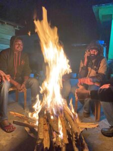 Les membres de l’expédition se réchauffent autour d’un feu de camp